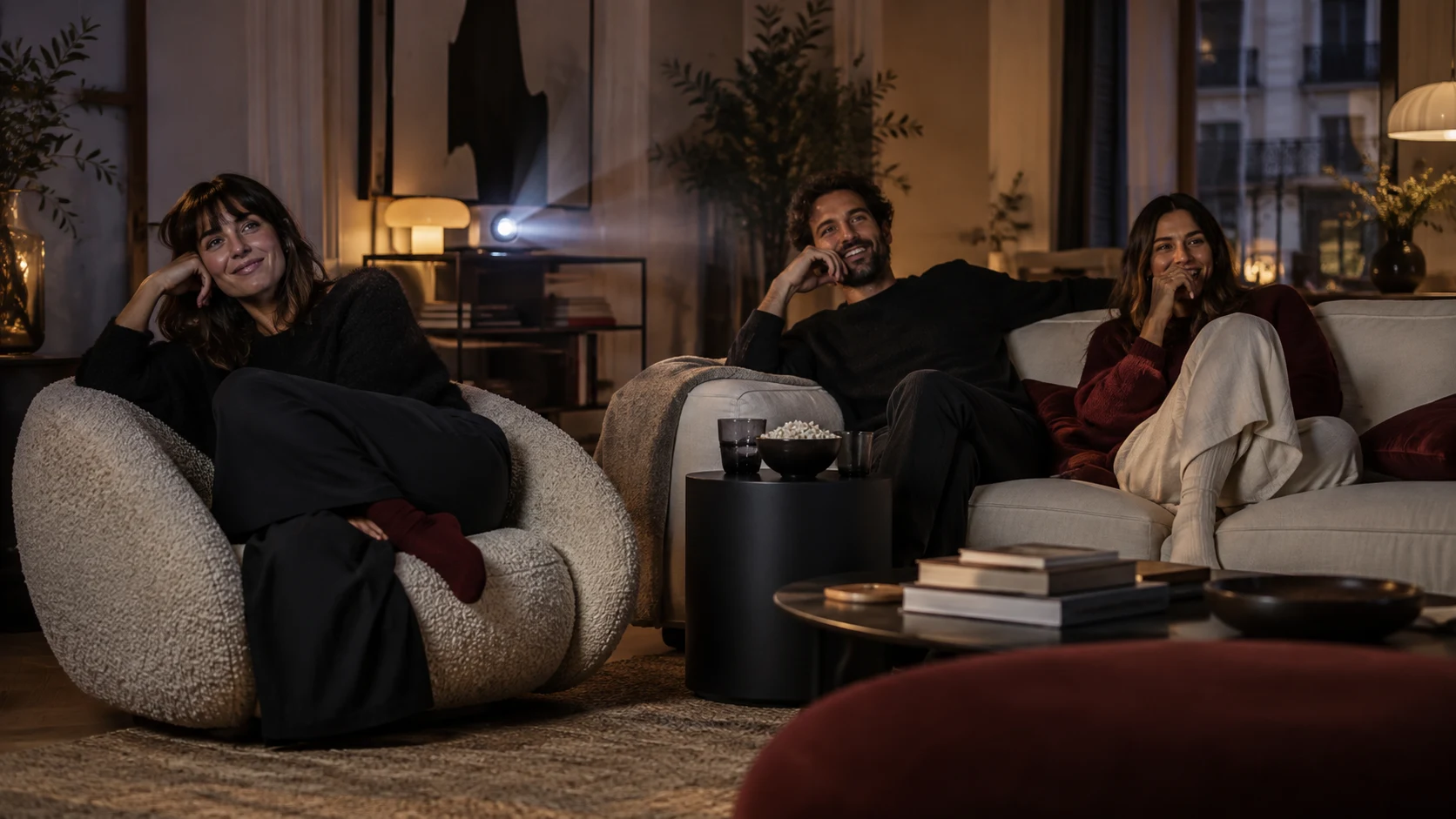 Tres amigos comparten una película en un salón de diseño contemporáneo
